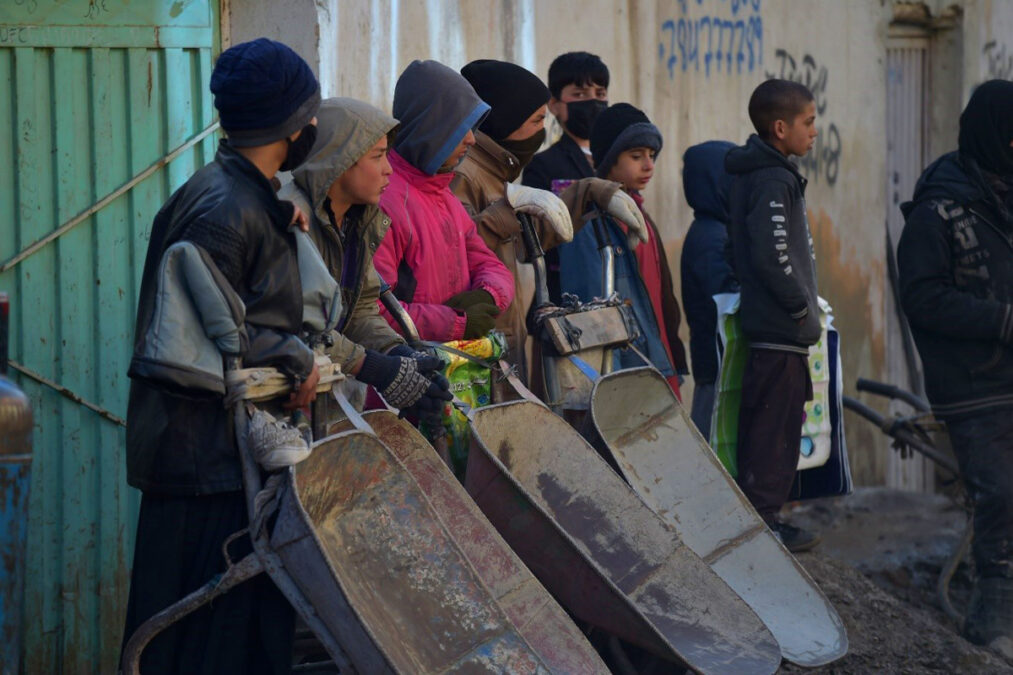 Children waiting in a queue to receive food in aid in Kabul on January 18, 2022.