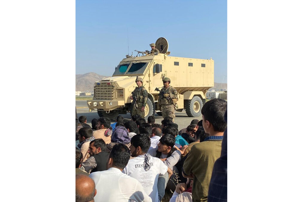 US forces standing near their vehicle to have a watch on a large number of Afghans who entered the Kabul airport on August 16, 2021, with the hope to be flown out of the country.