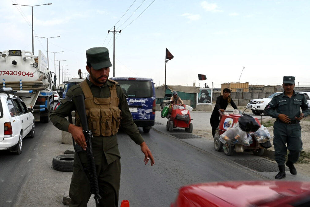 An Afghan police force member stopping a car at a check post in the north of Kabul on August 14, 2021, a day ahead of the fall of Kabul to the Taliban.